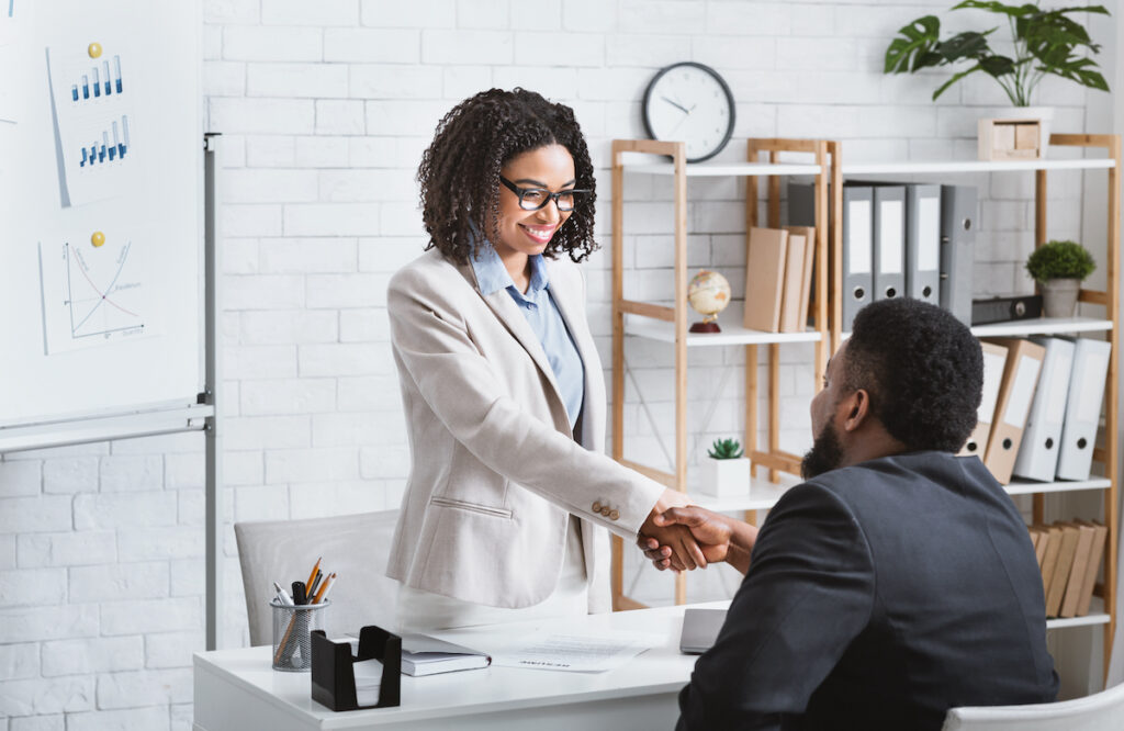 Black hiring manager shaking hands with successful vacancy candidate after work interview at office, copy space